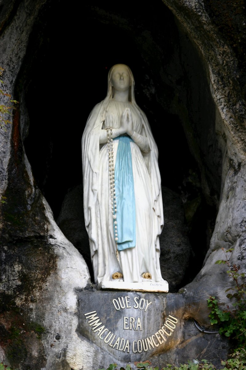 The statue of Our Lady of Lourdes by Joseph-Hugues Fabisch, placed in the grotto niche in 1864. The inscription reads in Occitan: Que Soy Era Immaculada Councepciou.